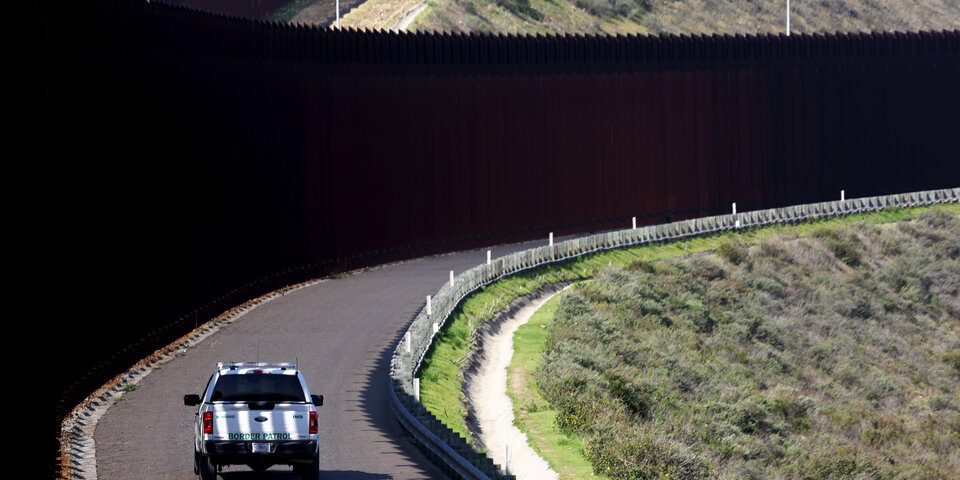 Border Patrol car driving along U.S.–Mexico border