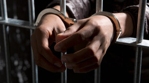 handcuffed behind bars