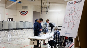 A poster with guidelines for safely coughing in the foreground of an image of a polling place.