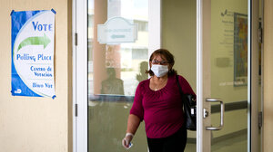 Voter in surgical mask exiting a polling place.