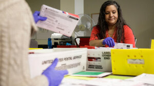 Ballot Processing Manager Jerelyn Hampton sorts vote-by-mail ballots by party for the presidential primary at King County Elections in Renton, Washington on March 10, 2020.