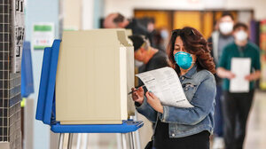 A woman casts her ballot in a Democratic presidential primary election at the Hamilton High School in Milwaukee, Wisconsin, on April 7, 2020.