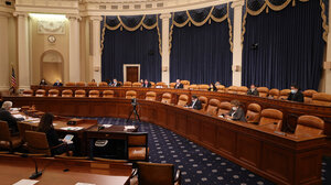 Legislators seated in a mostly empty chamber
