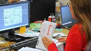 A Utah County election worker verifies signatures on mail-in ballots for the midterm elections on November 6, 2018 in Provo, Utah.
