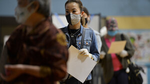 Woman in face-mask in line to vote