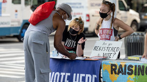 Man registering to vote at voter registration table