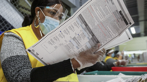 Poll worker looks at ballot