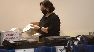 A poll worker scans ballots at the Maricopa County Recorders Office where votes in the general election are being counted, in Phoenix, Thursday, Nov. 5, 2020.