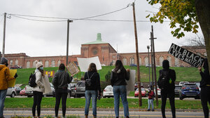 A group of Black Lives Matter protestors standing outside a correctional facility.
