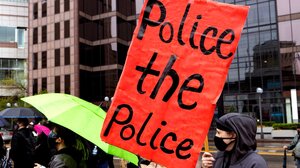 Protester holds sign, "Police the police."