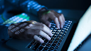 hands typing on computer keyboard