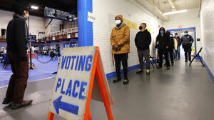 Voters line up in a hallway at their polling place
