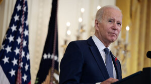 Joe Biden stands at the presidential podium in the White House