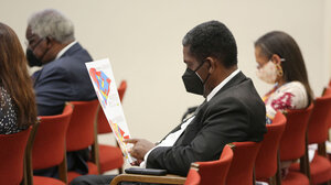 Man examines a map while sitting.