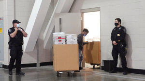 Police stand guard outside of a room in the Wisconsin Center where ballots are being stored