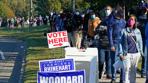 A long line of people waiting to vote, many of them Black, wraps around a street corner