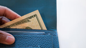 A close up shot of a 20 dollar bill bring taken out of a wallet