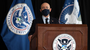 Secretary Alejandro Mayorkas speaking behind a podium