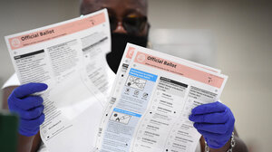 An election worker revises a ballot