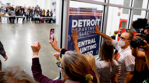 Protestors pound the door of a Detroit elections office