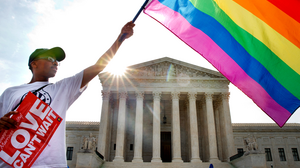Person waving pride flag in front of Supreme Court
