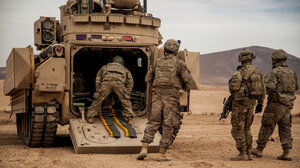 US soldiers in Syria unloading an armored vehicle in the desert