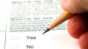 Hand holding a pencil over a ballot question