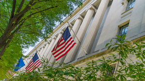 facade of the department of justice with American flags