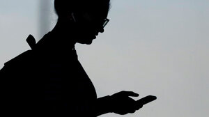 Silhouette of person looking at their phone