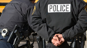 Police officer with hands behind back