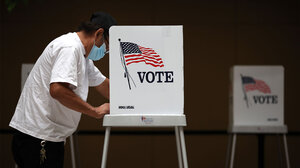 Man at voting booth in a mask