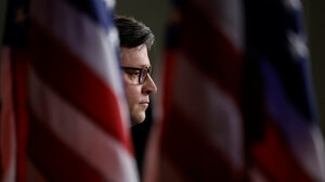 House Speaker Mike Johnson behind U.S. flag
