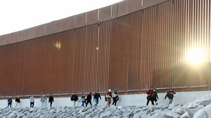 People walking at the US-Mexico border wall