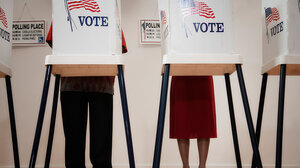 People standing behind a voting booth