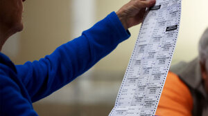 Election officials checks a voter's ballot.