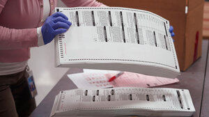 election official handling ballots with gloves