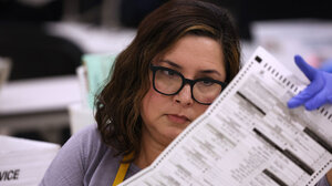 Election worker looking over a ballot.