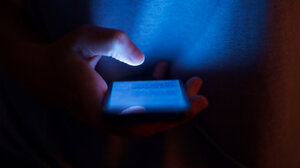 Person holding cell phone in the dark