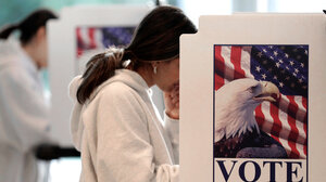 Woman voting behind divider