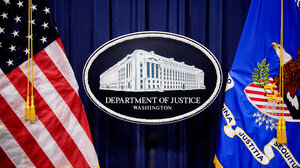 DOJ signage between two flags