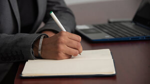 Foto de una mano con la escritura de bolígrafo en un cuaderno