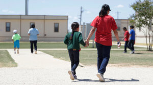 Mother and child walking in family detention center