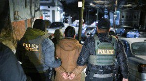 Immigration and Customs Enforcement officers arrest a man.