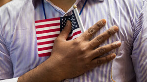 Man holding small American flag to chest