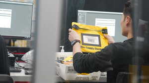 worker holding up yellow bag with Fulton County elections written on it