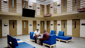 two incarcerated individuals playing chess in prison