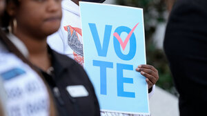 A voter standing next to a voting sign