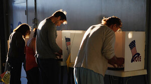 four voters casting ballots in privacy booths