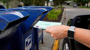 Mail ballot being dropped in mail slot